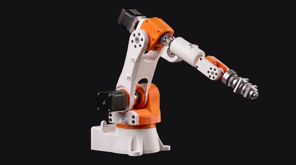 Braç robot d'escriptori muntat: peces impreses blanques i taronges, dos motors pas a pas negres i una eina d'alumini a la punta.